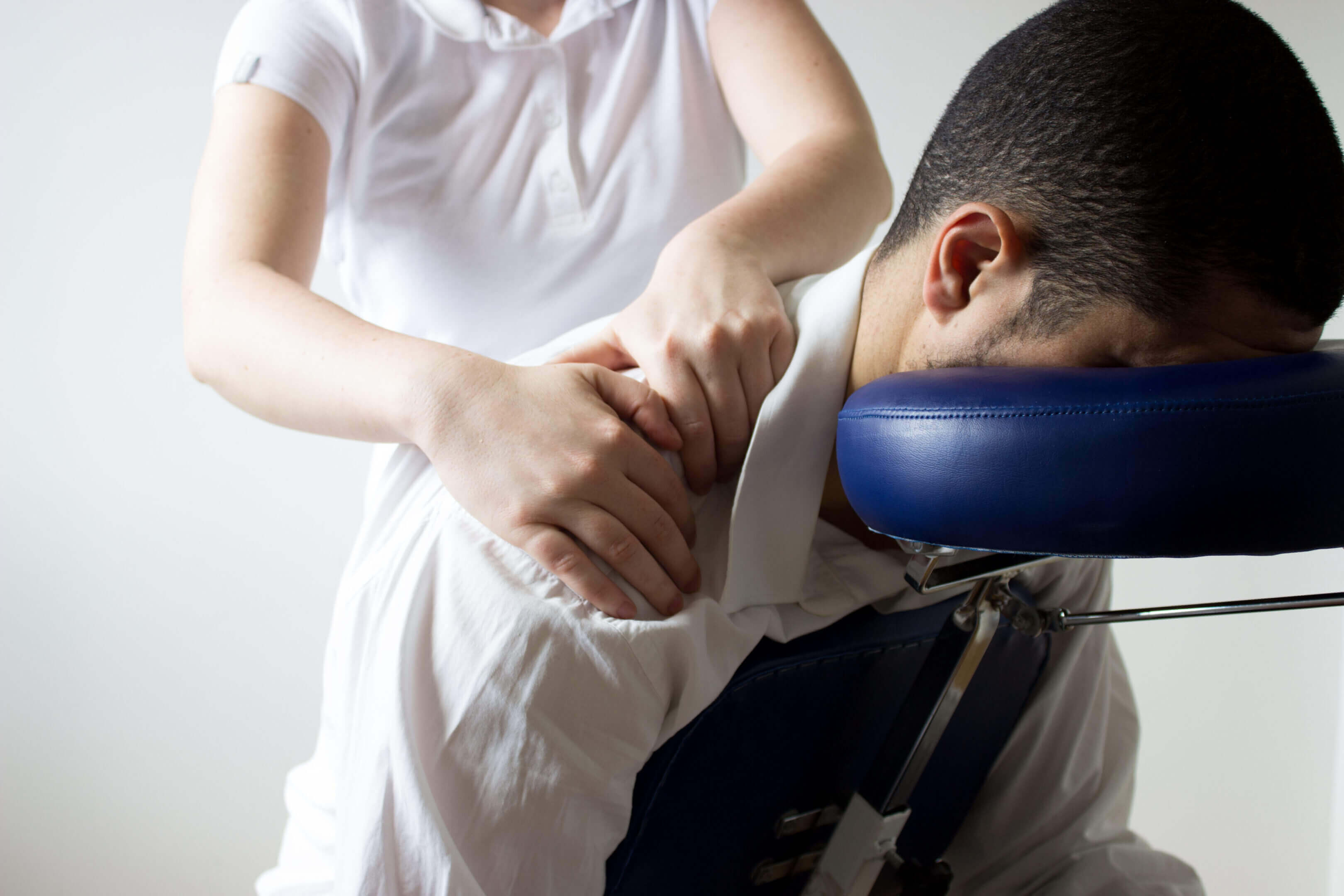 Chair massage: therapist's hands on client's shoulders.